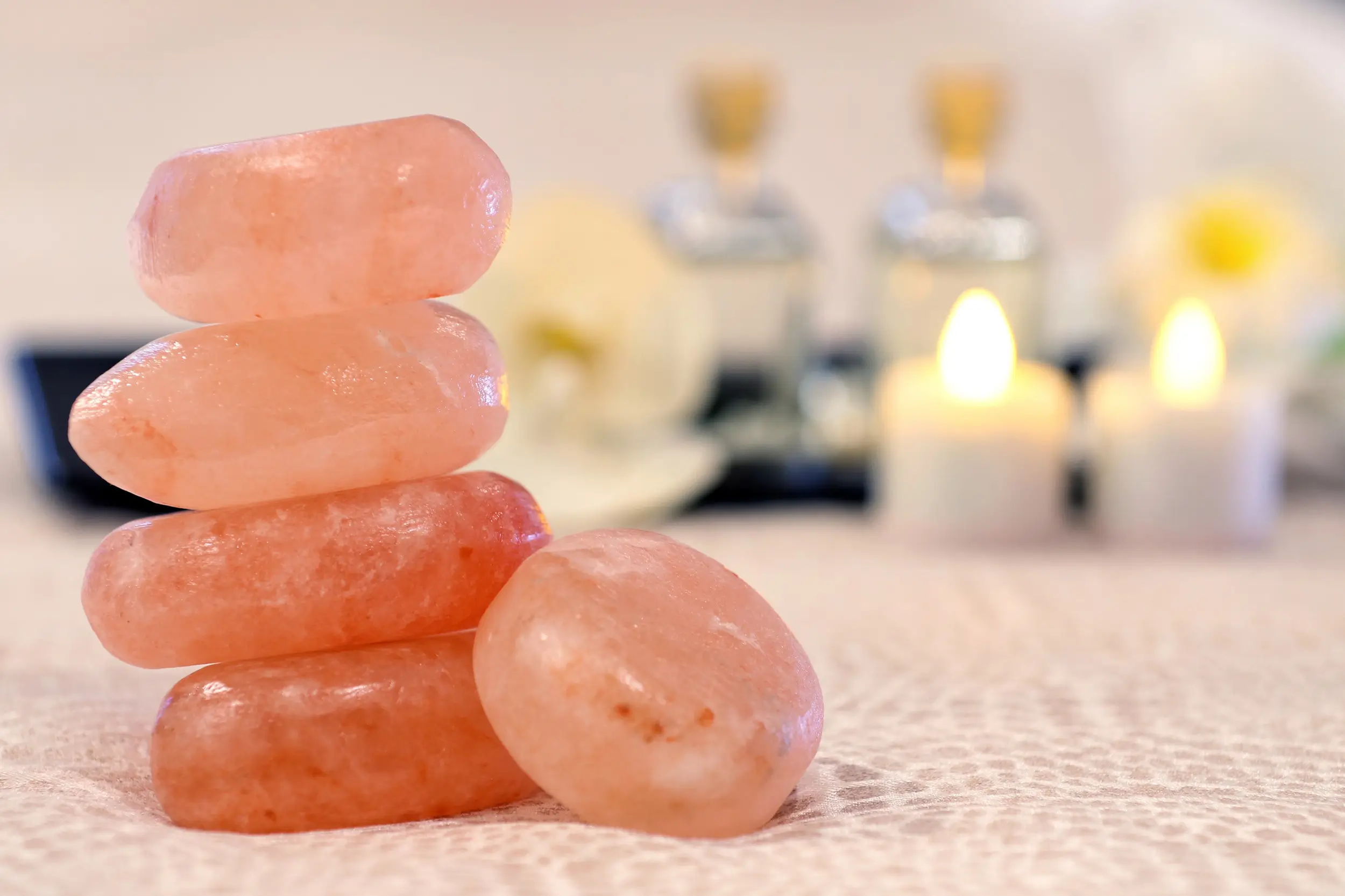 Stacked rose quartz spa stones with candles